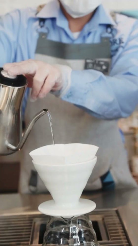 A barista pouring a V60 coffee